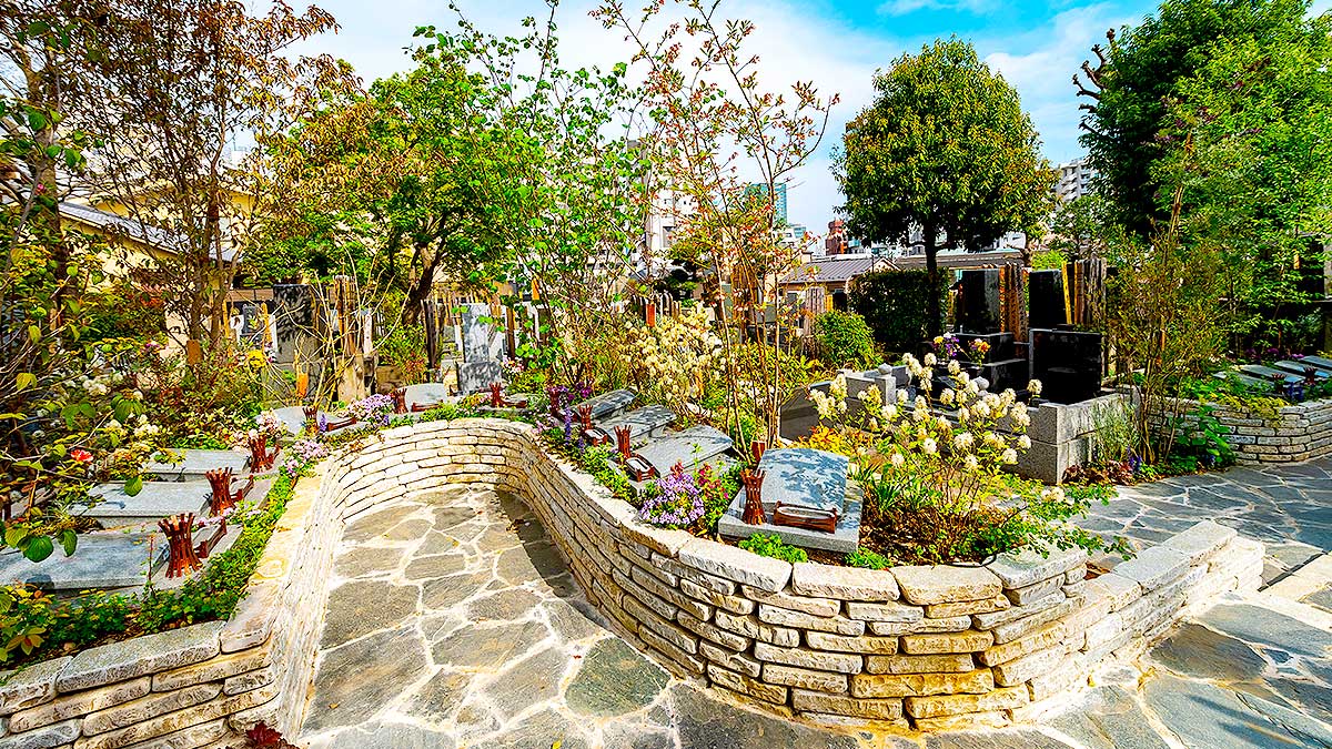 曲線状の参道に沿って配置された樹木葬墓地のプレート墓碑